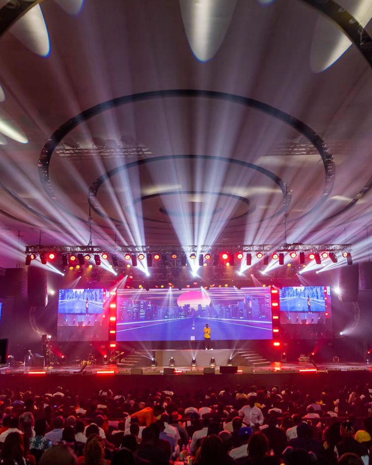 Crowd with hands raised at a concert with purple stage lights